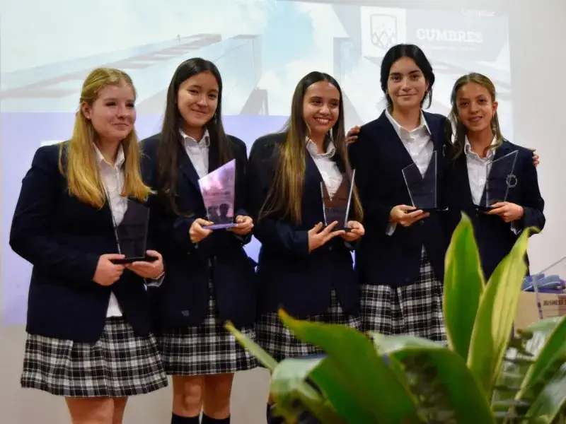 Cinco estudiantes de Cumbres reciben reconocimiento en ceremonia escolar sosteniendo premios